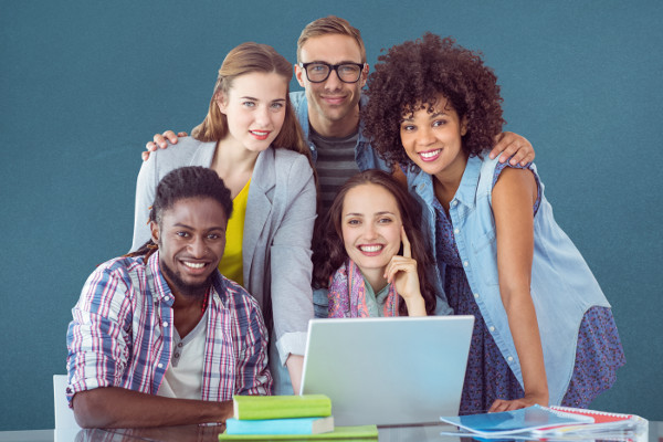 Five young smailing people staying behind laptop