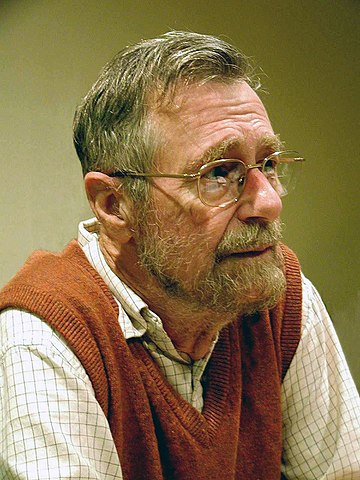 A face picture of an older man in glasses and beard